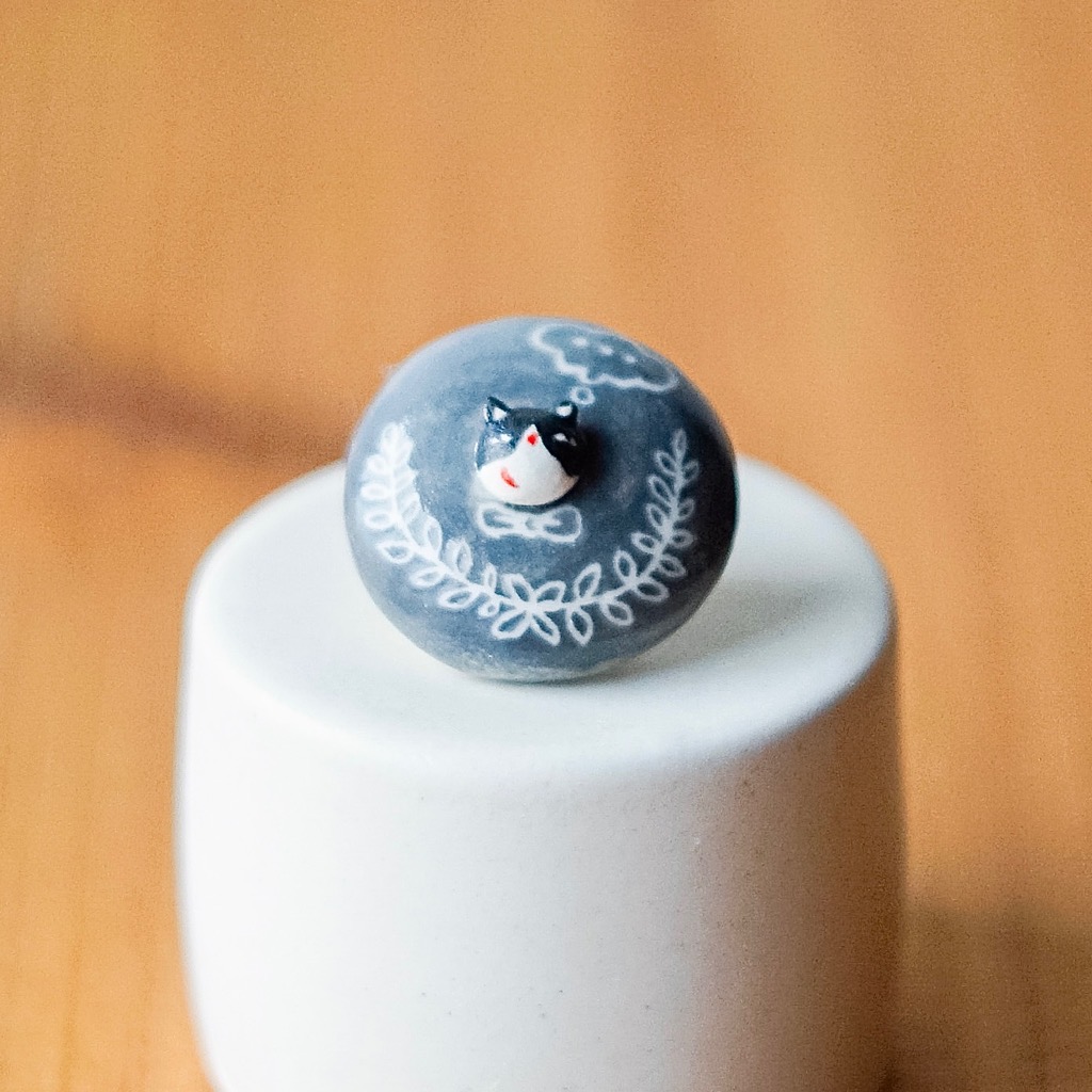 特製の台に載せた陶製のねこボタン