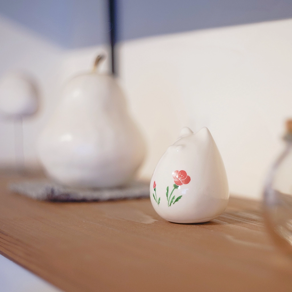 昭和レトロな花柄を施した陶製フィギュアぽたねこを横から撮影